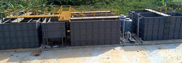 Row of modular STP tanks with yellow walkways and pressure filters on a paved site