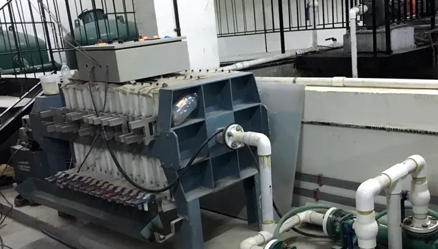 STP plant room with a sludge filter press, control panel and pumps